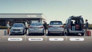 Four people stand by rental cars of different sizes—compact, midsize sedan, SUV, and large van—all labeled beneath each vehicle to help you choose rental car size. Two hold suitcases, with more luggage visible in the large van outside the "Car rental" building.